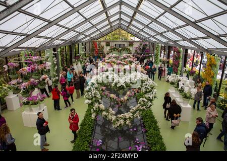 I visitatori si godono la bella mostra a forma di cuore di fiori di orchidee colorate nel padiglione delle mostre nei Giardini Keukenhof, Lisse, Olanda. Foto Stock