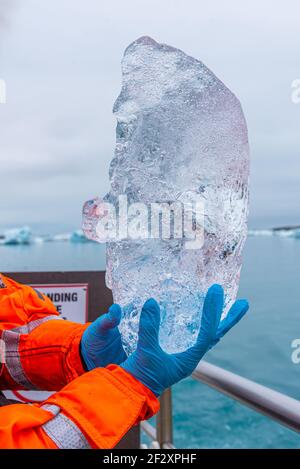 Pezzo di ghiaccio tenuto in mano alla laguna di Jokulsarlon su Islanda Foto Stock