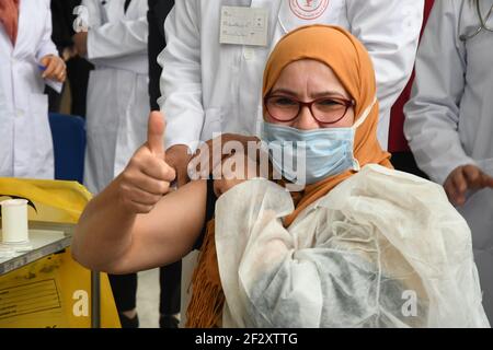 Tunisi, Tunisia. 13 Marzo 2021. Una donna dà un pollice in su mentre riceve il vaccino COVID-19 a Tunisi, Tunisia, il 13 marzo 2021. La campagna nazionale di vaccinazione contro COVID-19 è iniziata ufficialmente sabato nei 25 centri regionali della Tunisia. Credit: Adel Ezzine/Xinhua/Alamy Live News Foto Stock