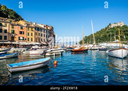 Portofino e Portofino vista dalla piazza centrale del paese. Il castello di Portofino, il Castello Brown, sullo sfondo di una collina Foto Stock