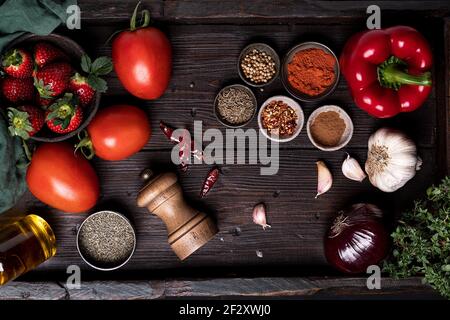 Vista dall'alto dei pomodori freschi maturi e delle fragole Tavolo in legno con spezie varie e ingredienti per zuppa Gazpacho ricetta Foto Stock