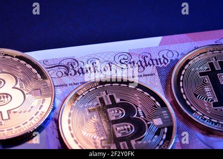 Moneta digitale moneta di metallo fisica moneta di bitcoin e sterlina valuta britannica. Concetto di criptovaluta. Foto Stock