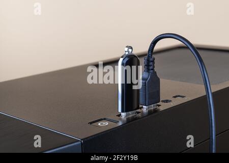 L'unità flash USB e il cavo USB sono entrambi inseriti nelle porte sulla parte superiore del case tower del computer. Dispositivo di trasferimento e memorizzazione delle informazioni. Connettori USB. Foto Stock