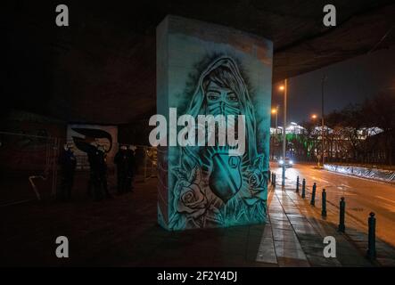 Varsavia, Varsavia, Polonia. 13 Marzo 2021. I poliziotti sono visti accanto a graffiti a tema Legia di fronte allo stadio di Legia il 13 marzo 2021 a Varsavia, Polonia. Circa un migliaio di tifosi della squadra di calcio di Varsavia Legia hanno partecipato a una manifestazione anti-governo contro le restrizioni del Covid-19 sotto lo slogan ''Open the Stadium'' che chiede almeno il 50% dei posti disponibili durante le partite. Credit: Aleksander Kalka/ZUMA Wire/Alamy Live News Foto Stock