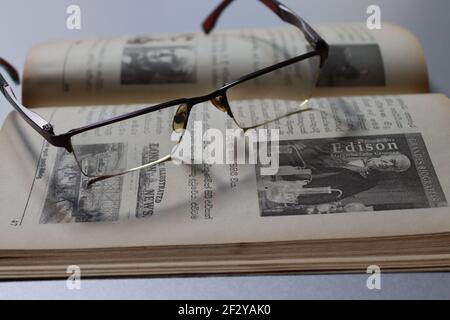 Il lettore è stanco; ha tenuto gli occhiali sul libro. Foto Stock