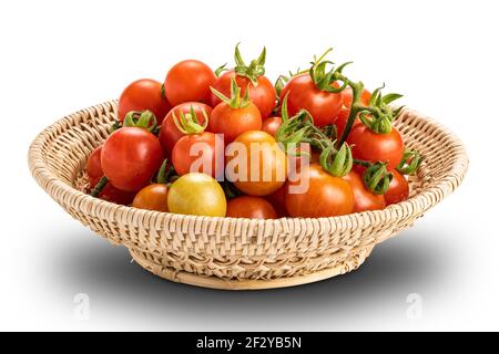 Vista closeup mucchio di pomodori maturi e succosi appena raccolti in cesto di bambù isolato su sfondo bianco con percorso di ritaglio. Toma matura, rossa, succosa Foto Stock