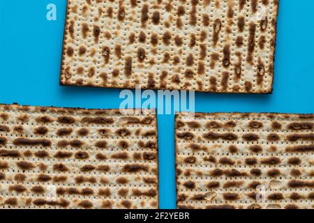 Un primo piano di tre matzah - pane per la Pasqua ebraica, su uno sfondo azzurro Foto Stock