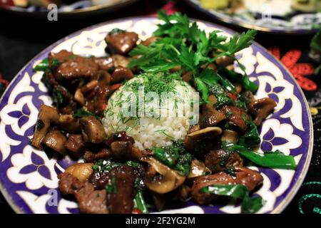 Arrosto di vitello con funghi e riso sul piatto Foto Stock