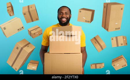 Happy boy riceve un sacco di pacchetti da ordine di negozio online. Sfondo blu. Foto Stock