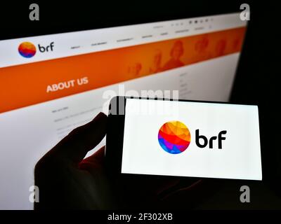 Persona che detiene smartphone con logo della società brasiliana di trasformazione alimentare BRF S.A. sullo schermo di fronte al sito web. Mettere a fuoco il display del telefono. Foto Stock