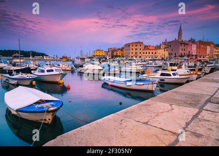 Incredibile paesaggio urbano con barche ancorate al porto all'alba, Rovigno, Istria, Croazia, Europa Foto Stock