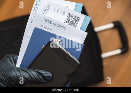 Concetto di viaggio post covid 19, certificato di vaccino e pass di immunità. Biglietto d'imbarco aereo e passaporto biometrico in mano umana Foto Stock