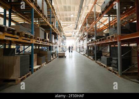 Lavoratori non riconoscibili che camminano in magazzino in fabbrica Foto Stock