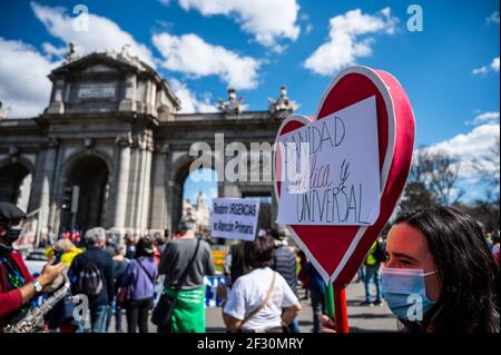 Madrid, Spagna. 14 Marzo 2021. Un manifestante che porta un cartello con la scritta "Sanità pubblica e universale" durante una dimostrazione a sostegno del sistema sanitario pubblico. I dimostranti protestano contro la gestione della crisi del coronavirus (COVID-19) da parte del presidente regionale di Madrid Isabel Diaz Ayuso e chiedono le loro dimissioni. Credit: Marcos del Mazo/Alamy Live News Foto Stock