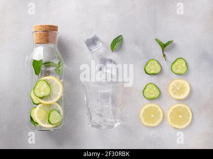 bottiglia di vetro con acqua infusa con limone, cetriolo, menta Foto Stock