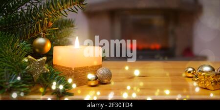 Sfondo di Natale con candela bruciante, camino e albero di Natale decorato Foto Stock