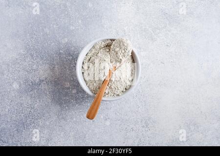 Collagene chiuso in una ciotola di ceramica su un vecchio fondo di cemento grigio. Disposizione piatta con spazio per la copia Foto Stock