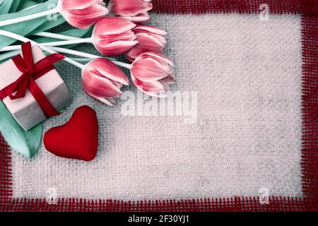 San Valentino con tulipani e cuore rosso su tessuto sfondo. Foto Stock