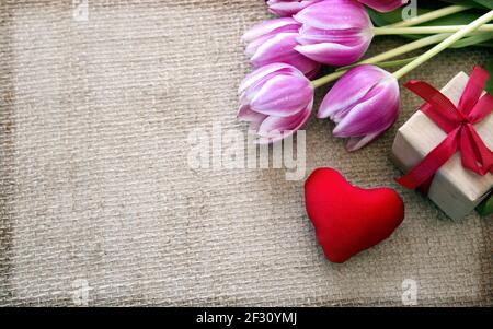 San Valentino con tulipani e cuore rosso su tessuto sfondo. Foto Stock