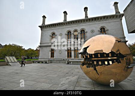 Vista esterna della Berkeley Library con la splendida scultura artistica "dentro la sfera" di Arnaldo Pomodoro al Trinity College, Dublino, Irlanda. Foto Stock