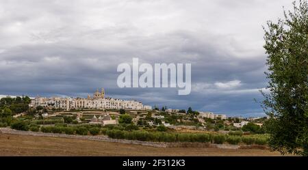 Vista dello skyline di Locortondo in Puglia da un campo di ulivo Foto Stock