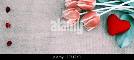 San Valentino con tulipani e cuore rosso su tessuto sfondo. Foto Stock