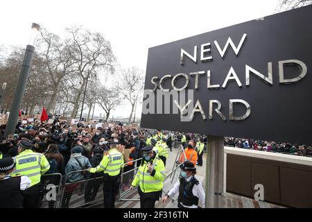 La polizia fuori New Scotland Yard a Londra, mentre i membri del pubblico si riuniscono per una veglia, il giorno dopo gli scontri tra la polizia e la folla che si sono riuniti su Clapham Common sabato sera per ricordare Sarah Everard. La polizia metropolitana ha dovuto affrontare critiche intense per la sua gestione della veglia, con ufficiali accusati di 'afferrare e maneggiare' le donne durante gli scontri con la folla. Data immagine: Domenica 14 marzo 2021. Foto Stock