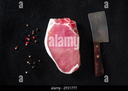 Bistecca di maiale, sparata dall'alto su sfondo nero Foto Stock