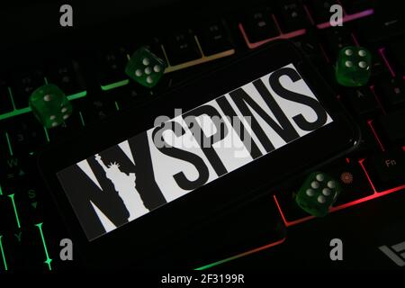 Viersen, Germania - 1 marzo. 2021: Closeup di smartphone con logo scritta di nyspins gioco online casinò sulla tastiera del computer Foto Stock
