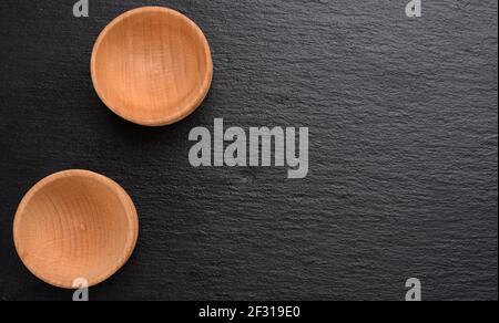 Due piccole piastre di legno vuote su sfondo nero Foto Stock