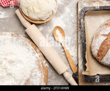 Farina di grano bianco colma su una tavola rotonda di legno Foto Stock