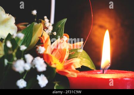 Candela rossa e fiore arrangiamento Foto Stock