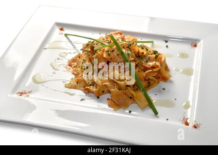 Pappardelle con salsa di pomodoro e prezzemolo tritato piastra quadrata isolata su bianco Foto Stock