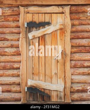 Porta anteriore in legno ad una rustica capanna di tronchi Foto Stock