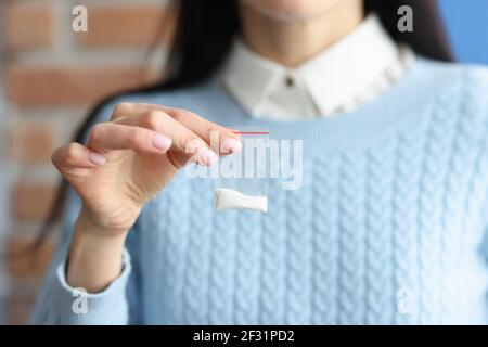 La donna tiene in mano un piccolo pacchetto di polvere bianca Foto Stock