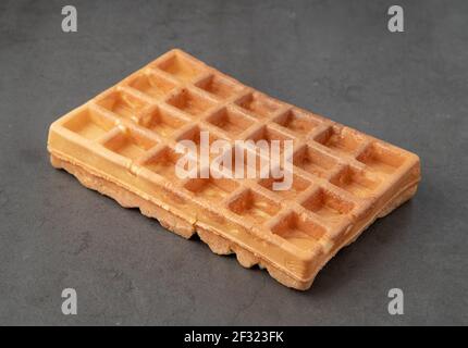 Waffle belgi singoli su sfondo di pietra scuro. Foto Stock
