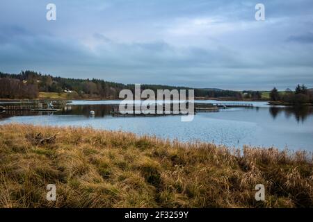 Allevamento ittico di trote a Kendoon Loch al tramonto in inverno, vicino a Carsphairn, sul Galloway Hydro Electric Scheme, Scozia Foto Stock