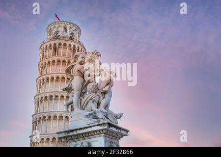 Statua degli angeli su Piazza dei Miracoli a Pisa e Torre Pendente, Italia contro il colorato cielo del tramonto Foto Stock