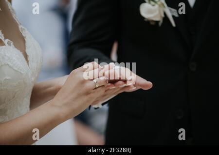 La coppia irriconoscibile che si scambiano anelli durante la cerimonia nuziale Foto Stock