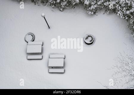 Vista aerea degli alberi ricoperti di neve e patio coperto di neve con tavoli da picnic, inverno a NDG, Montreal, QC Foto Stock