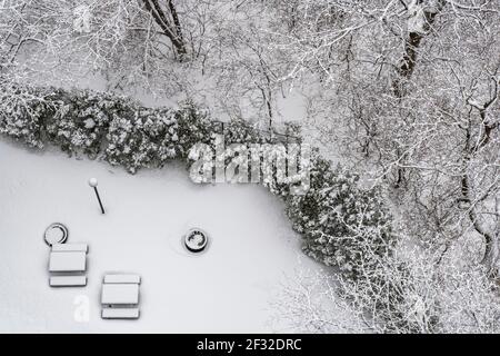 Vista aerea degli alberi ricoperti di neve e patio coperto di neve con tavoli da picnic, inverno a NDG, Montreal, QC Foto Stock