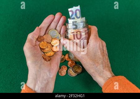 Simbolo foto, pensione, anziano, mani, denaro, banco di piggy Foto Stock