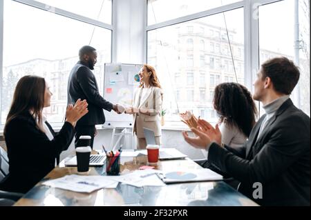 Persone di successo che arrivano ad un accordo durante le trattative, scuotendo le mani. Imprenditori eleganti e sicuri firmano un contratto al concetto di conferenza, collaborazione e partnership Foto Stock