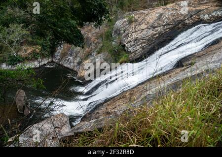 Il flusso d'acqua della cascata di Pimenta che scende sopra le formazioni rocciose a gradino medio all'interno della foresta di Sea Ridge (Serra do Mar), campagna di Cunha. Foto Stock