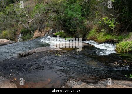 Il flusso d'acqua della cascata di Pimenta che scorre sulle formazioni rocciose della media foresta di Sea Ridge (Serra do Mar) nella campagna di Cunha. Foto Stock