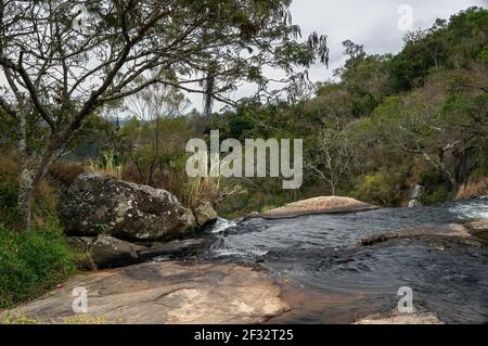 Il flusso d'acqua della cascata di Pimenta che scorre sulle formazioni rocciose della media foresta di Sea Ridge (Serra do Mar) nella campagna di Cunha. Foto Stock