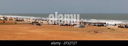 Attività ricreative all'aperto lungo chilometri di spiaggia ad Accra, Ghana. Famiglie e amici si riuniscono per divertimento, sport, nuoto e competizione. Foto Stock