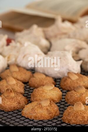 Biscotti per il festival ebraico di Pasqua (Pesach). Biscotti di amaretto alle mandorle e torte di meringa al cocco, presentati su un vassoio di raffreddamento a filo Foto Stock