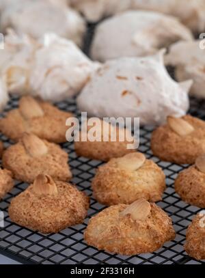 Biscotti per il festival ebraico di Pasqua (Pesach). Biscotti di amaretto alle mandorle e torte di meringa al cocco, presentati su un vassoio di raffreddamento a filo Foto Stock