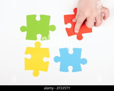 un bambino con autismo raccoglie puzzle, insegnare ai bambini Foto Stock